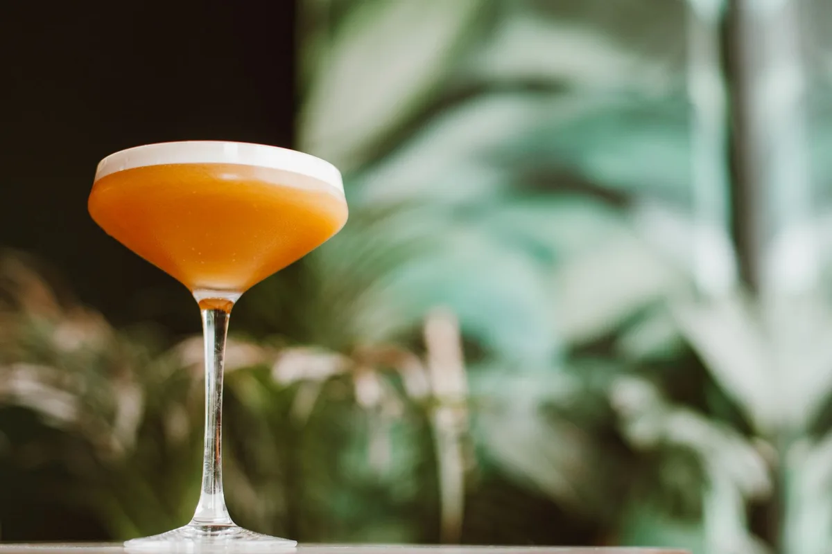 A refined Bellini Margarita served in a chilled coupe glass with lime wheel garnish