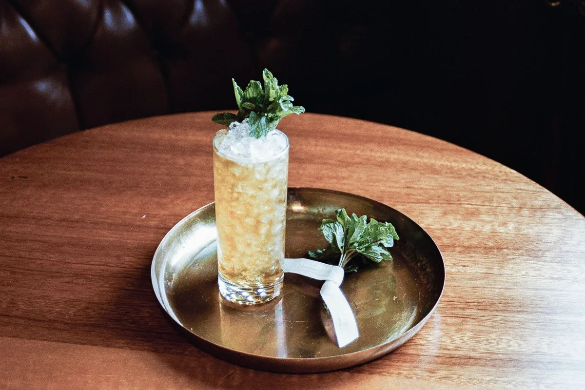 Rhinestone Cowboy cocktail in a rocks glass with mint garnish and ginger beer fizz