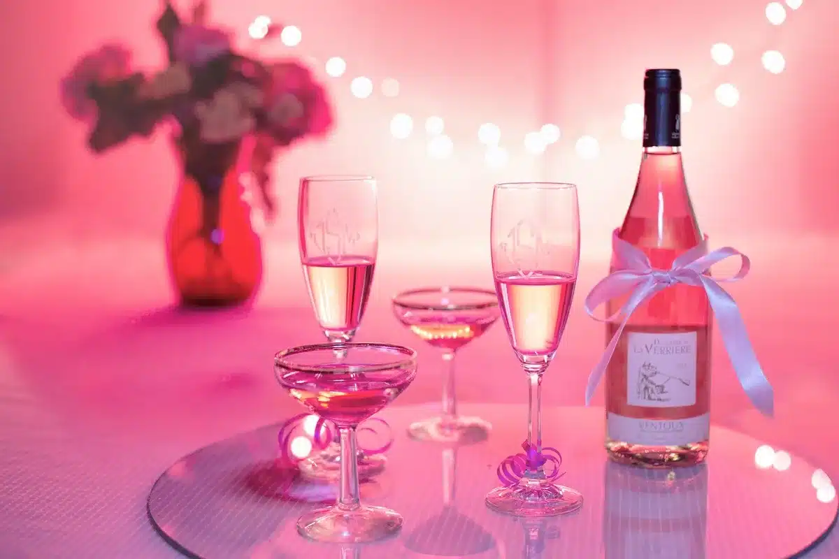 Pouring sparkling wine into a chilled flute with a berry inside