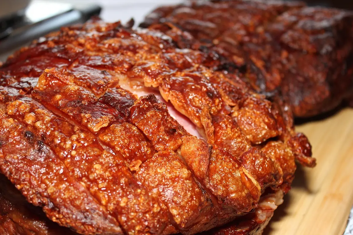 Pork roast browning in a hot skillet before going into a slow cooker