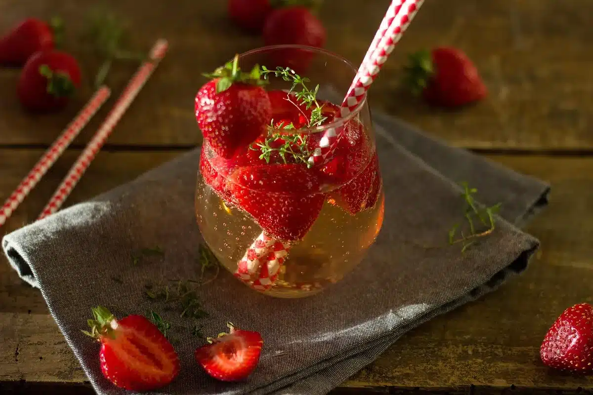 Highball cocktail filled with ice and fruit garnish showing a long fruity drink