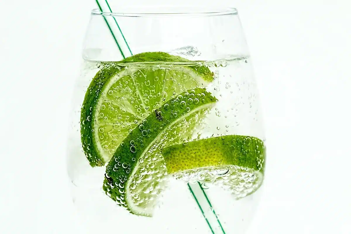Shaker being strained into a chilled coupe glass over a well-lit bar surface
