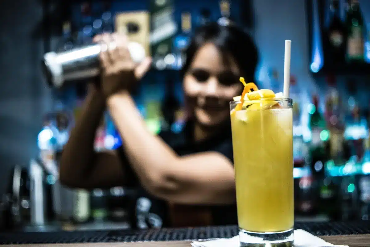 Shaker and chilled coupe in daylight as a cocktail is double-strained