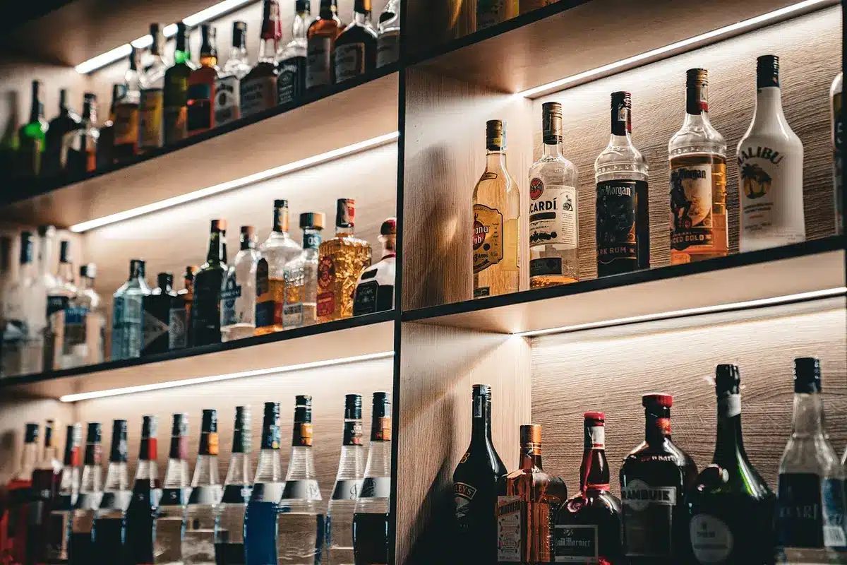 Glass being topped with tawny port beside a blurred bottle